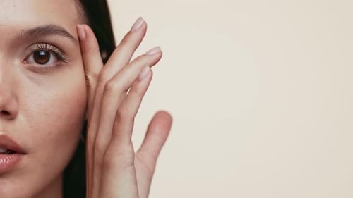 Young Adult Woman Touching Her Face In Close Up