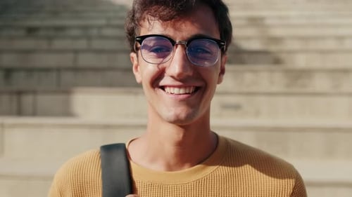 Smiling Young Man Wearing Glasses and Backpack