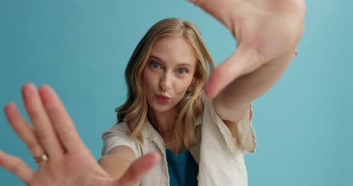 Smiling Woman Posing in Front of Blue Background