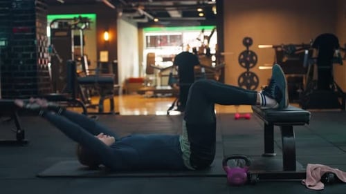 Caucasian man exercises on a yoga mat at gym. Male fitness model performing abs crunches - static