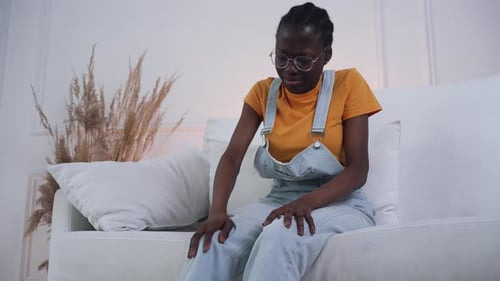 Woman Sitting on Couch with Knee Pain