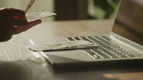 Counting Cash Near Laptop Computer, Close-Up