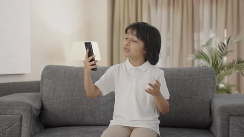 Child Chatting on Cellphone Video Call at Home