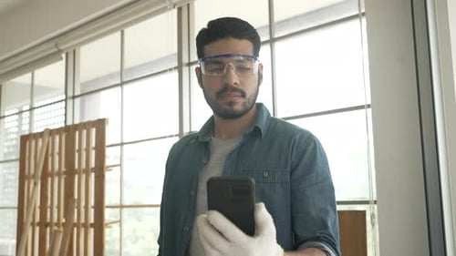 Carpenter is working at woodshop.