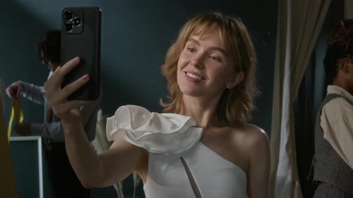 Mulher caucasiana tirando selfies no espelho na loja de noivas