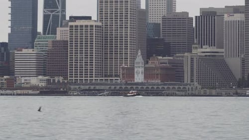 Small Boat Sails across the San Francisco Bay in Front of the Historic Ferry Building.