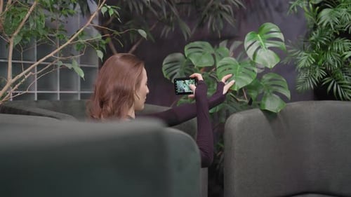 Woman taking a photo of plants with her phone