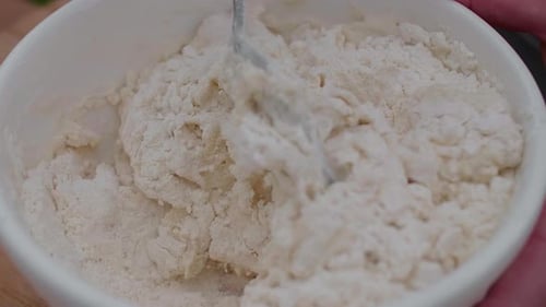 Mixing Flour and Dough in Bowl with Spoon