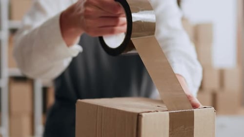 Kleinunternehmer, Geschäftsfrau, packt Kartons selbst, um sie an Käufer und Kunden zu senden, verpackt Kartons