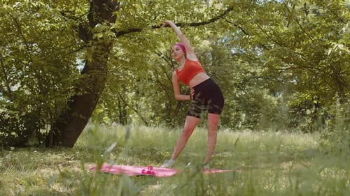 Sporty Young Woman Athlete Doing Stretching Fitness Tilts Exercises Workout Outdoors in Sunny Park