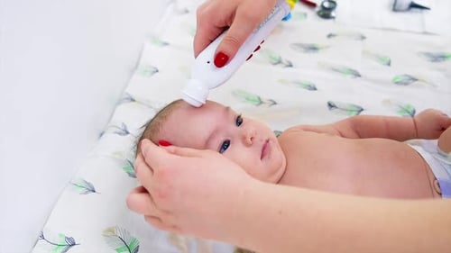 Infant Having Temperature Taken with Thermometer
