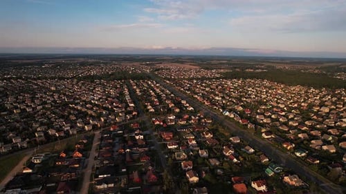 Aerial View of Even Rows of Singlefamily Houses in the Suburbs in a Picturesque Area Surrounded By
