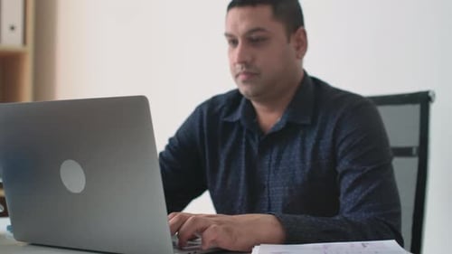 Man Working on Laptop at Office Desk