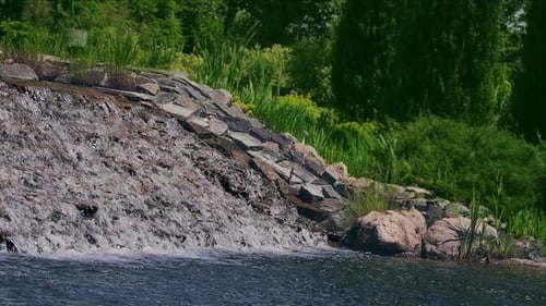 Waterfall cascade flows smoothly in beautiful garden park setting