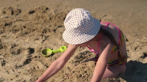 Child Playing with Sand on Beach