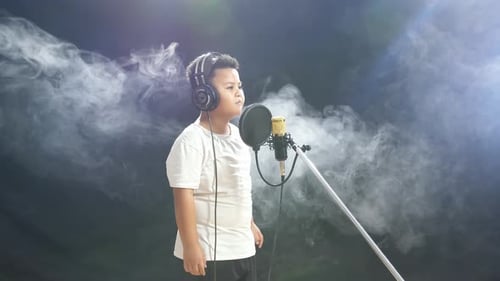 Young Child Sings into Microphone in Foggy Studio