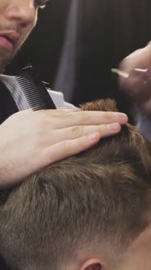 Barber Cutting Hair with Scissors and Comb