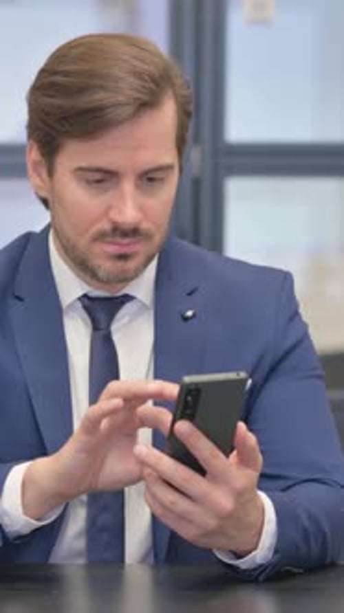 Businessman Using Mobile Phone in Office, Vertical Video