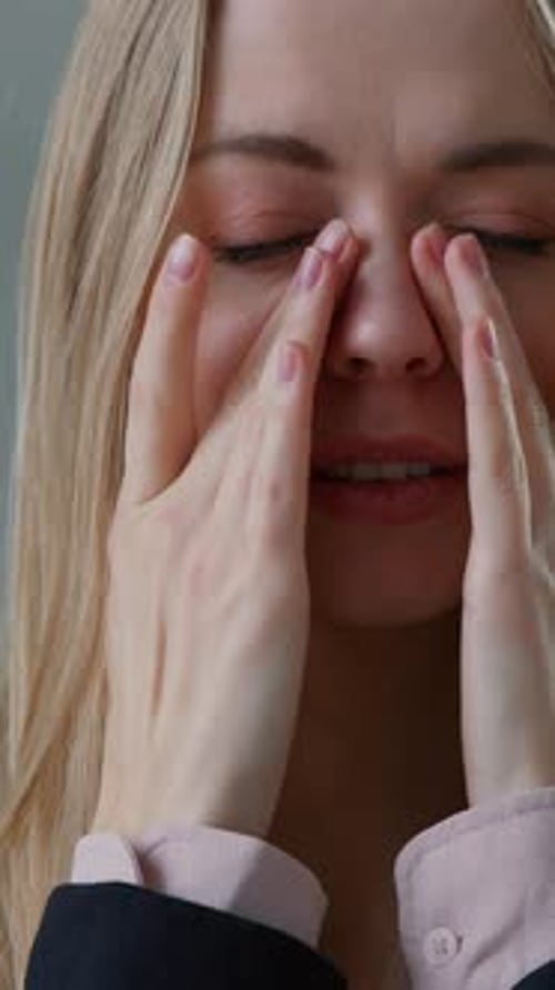 Stressed Woman Massaging Her Face with Hands
