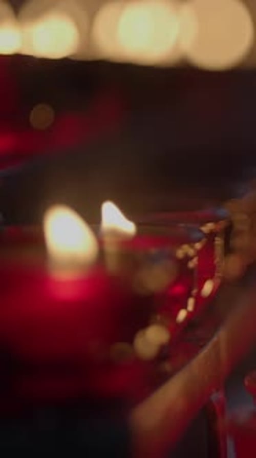 D'élégantes bougies rouges brillent doucement dans le noir, créant une atmosphère sereine