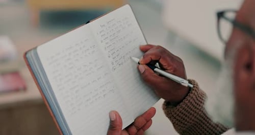 Senior writes in notebook with silver pen