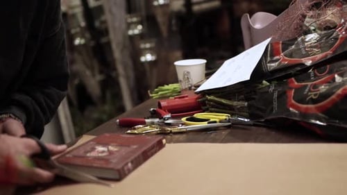 Florist Cuts Wrapping Paper for a Bouquet