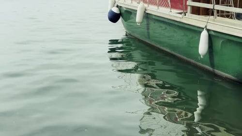 Reflection Of A Green Boat Hull In Calm Sea Water