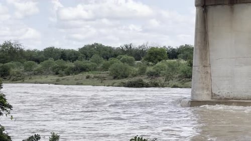 Flooded river quickly flowing below a bridge