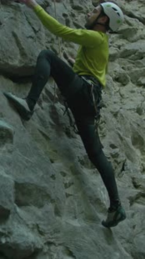 Extreme Hiker Young Bearded Man in Helmet Bright Yellow Sportswear Climbing Limestone Rock Cliff
