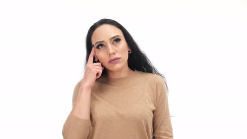 Woman Thinking with Finger on Forehead Indoors