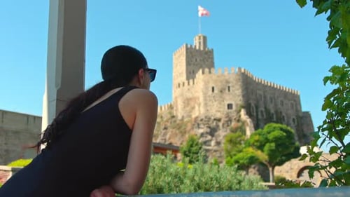 Woman Admiring a Castle From a Balcony
