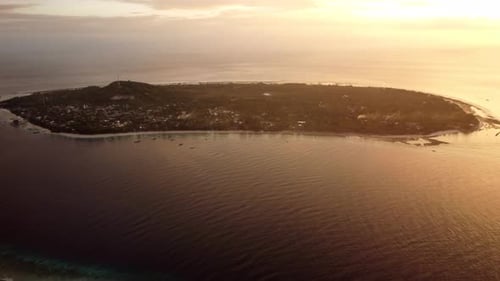 Aerial sunset isolated island in the ocean, tropical paradise