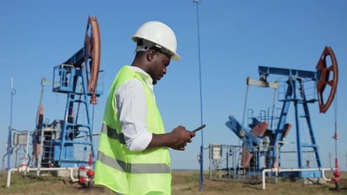 Black Engineer kontrolliert die Entwicklung von Öl von Jackpump