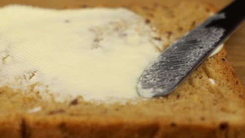 Butter Being Spread on a Slice of Bread
