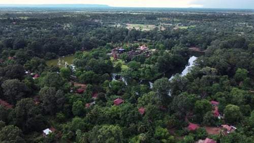 Aerial shot from outskirts of Angkor Wat showing some ruins and the surrounding countryside. Drone
