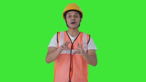 Happy Indian construction labour talking to someone Green screen