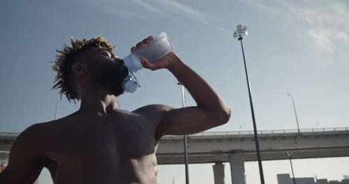 Man Drinking Water After Workout in City