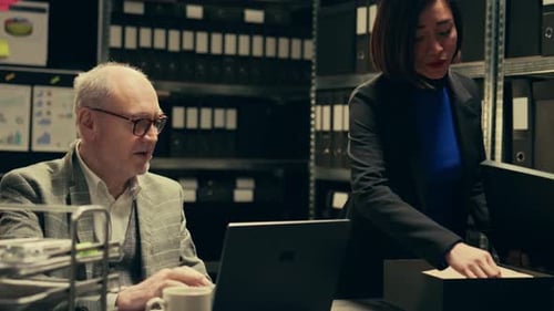 Man and Woman Working at Dark Office