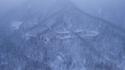 Aerial view of winding road on snow-covered mountain, Japan.