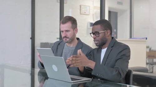 Business People Discussing Work on Laptop and Digital Tablet