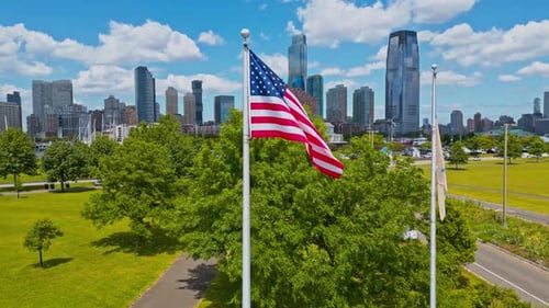 American Flag Waving Above Green Cityscape, Aerial View