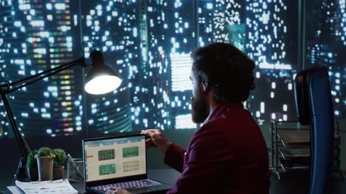 Man Working Late on Laptop in Modern Office