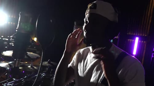 Young african american artist recording music in studio