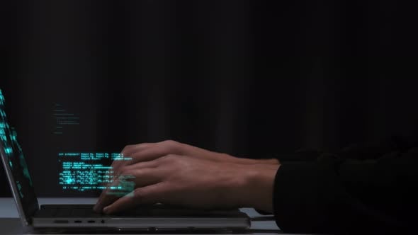 Programmer's fingers quickly type computer code on the laptop keyboard ...