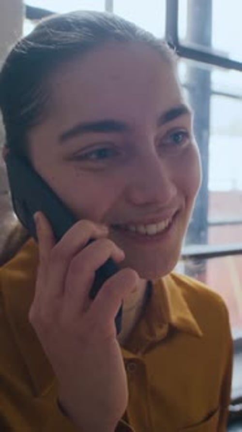 Happy Woman Chatting on Cellphone Indoors