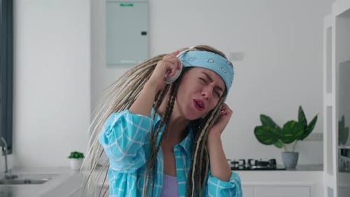 Woman Dancing in Kitchen with Headphones