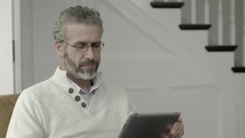 Mature Man Relaxing at Home Using a Tablet