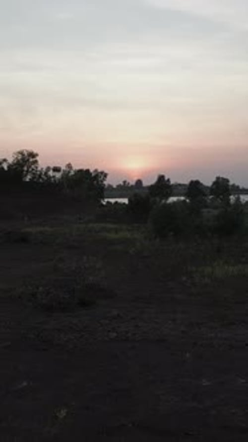 Drone survolant les forêts près d'un lac en basse lumière avant le coucher du soleil dans les lacs de Long Thanh au Vietnam