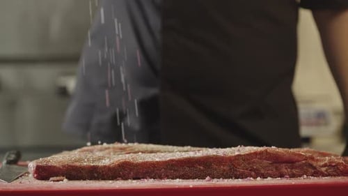 A Chef Salting Ribs in a Restaurant Kitchen