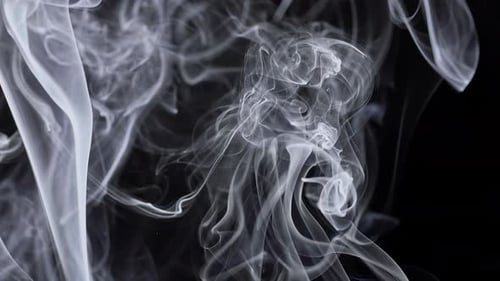 Wispy white smoke streams across a dark background